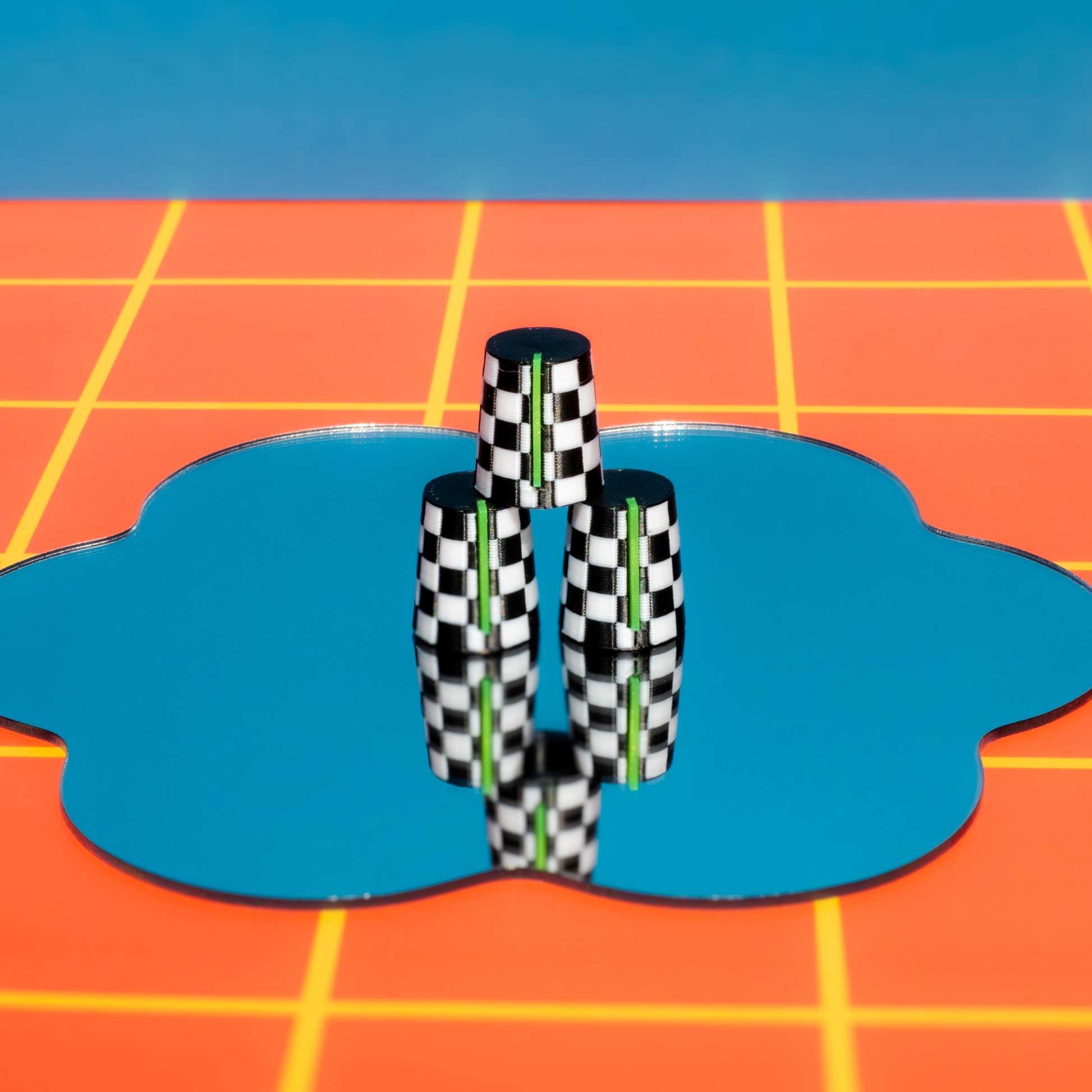 Checkered Synth and DJ Knobs objects on a blue circular platform with a grid-patterned background