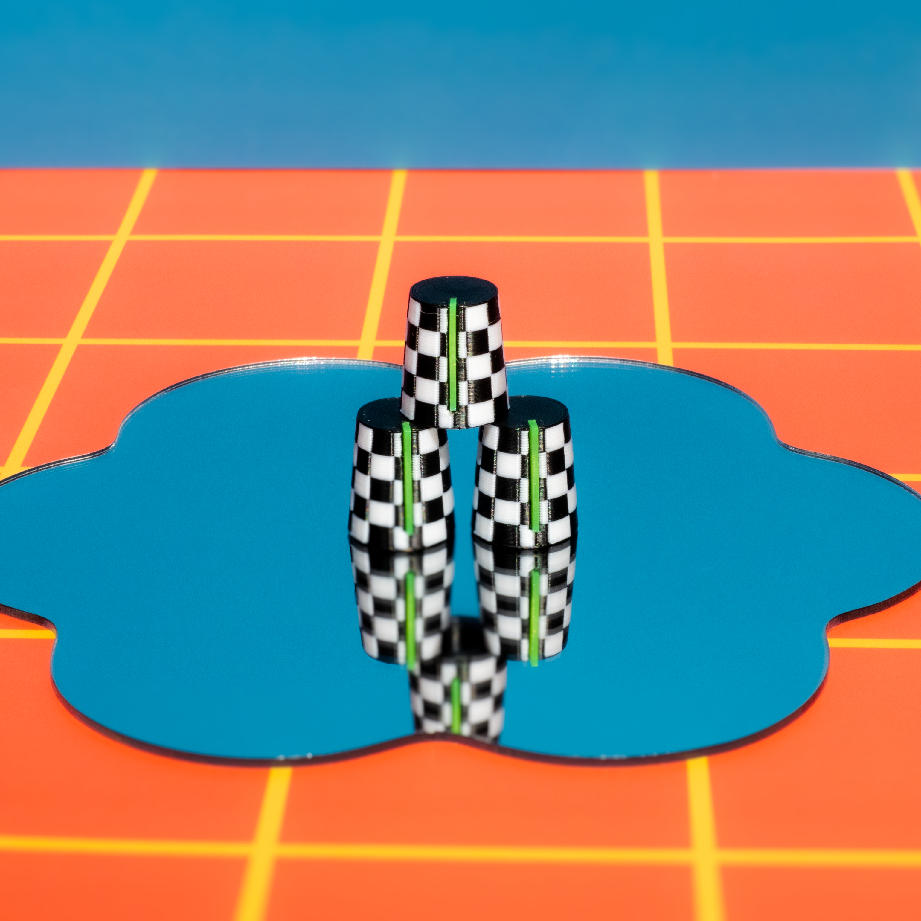Checkered Synth and DJ Knobs objects on a blue circular platform with a grid-patterned background