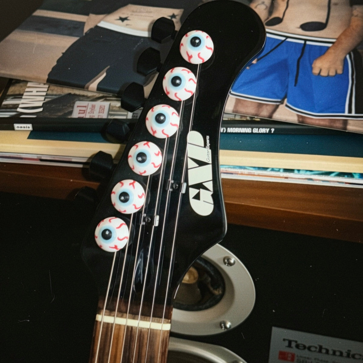 Eyeball tuner caps on a guitar headstock